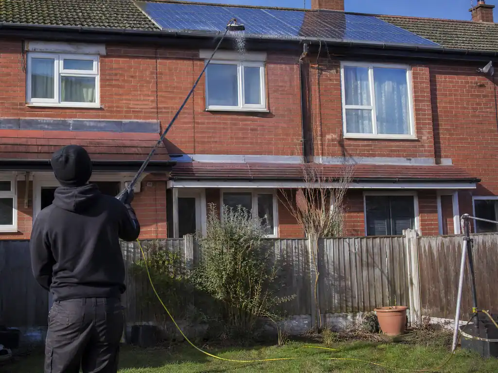 Solar panels being cleaned with a water-fed pole on a Birmingham semi-detached house
