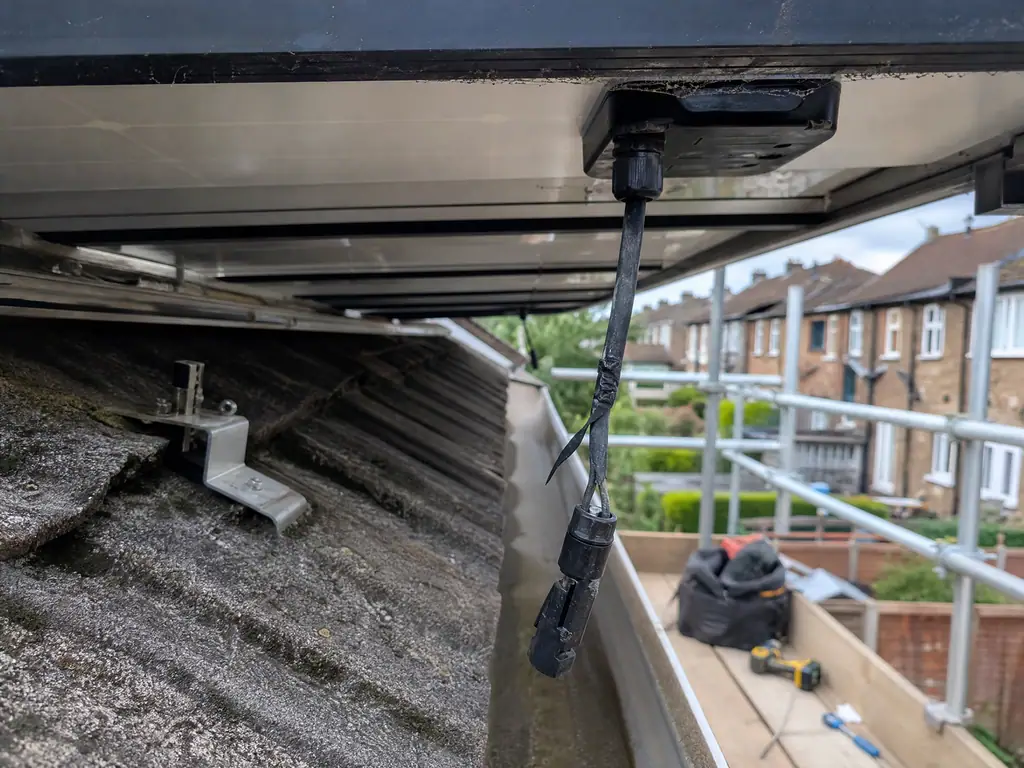 Loose damaged solar cable hanging below the panels before repair, Birmingham
